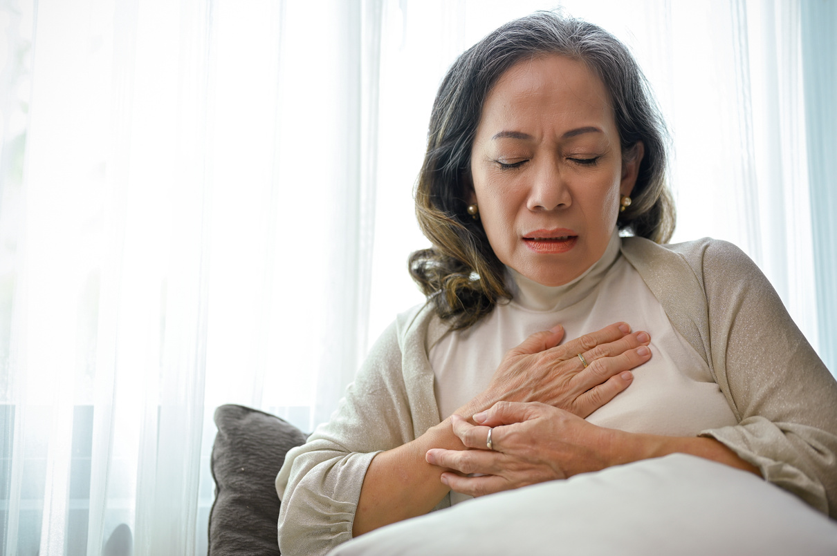 A sick Asian middle-aged woman with heart disease or heart ache,